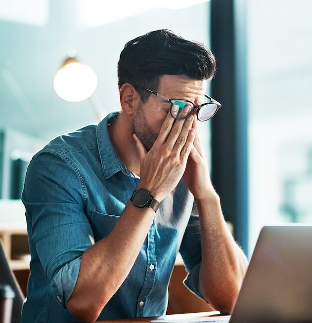 Headache, stress and tired business man at laptop in office for anxiety, debt crisis and eye strain problem